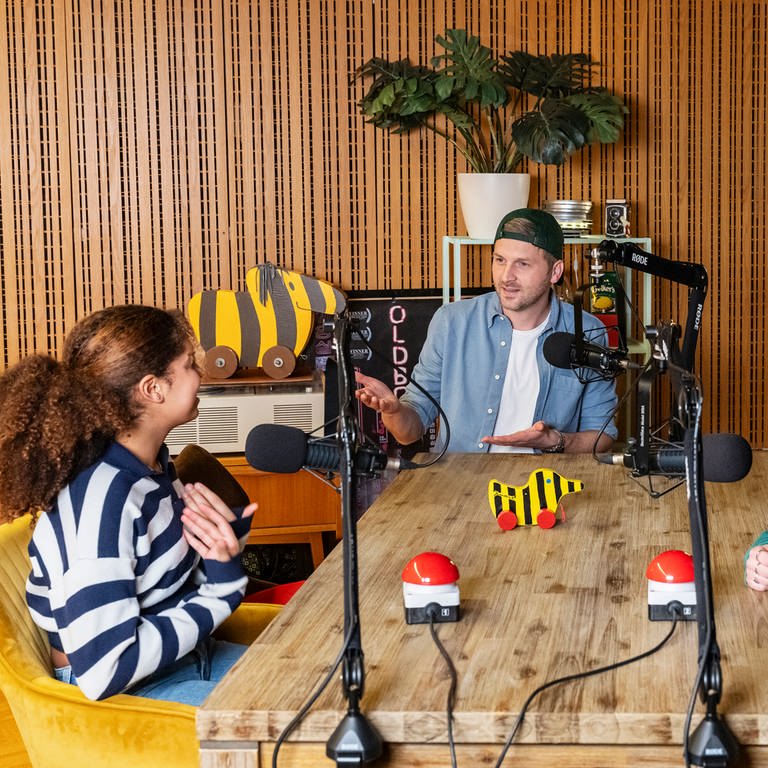 Johannes Zenglein begrüßt zwei Kinder im Podcast "Tigerenten Club - Die Hör-Spiel-Show" (Foto: SWR)